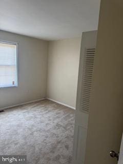 empty room featuring baseboards and carpet