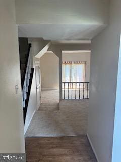 hallway with stairs, baseboards, and wood finished floors