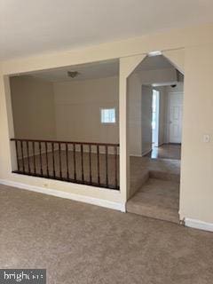 empty room featuring carpet floors and baseboards