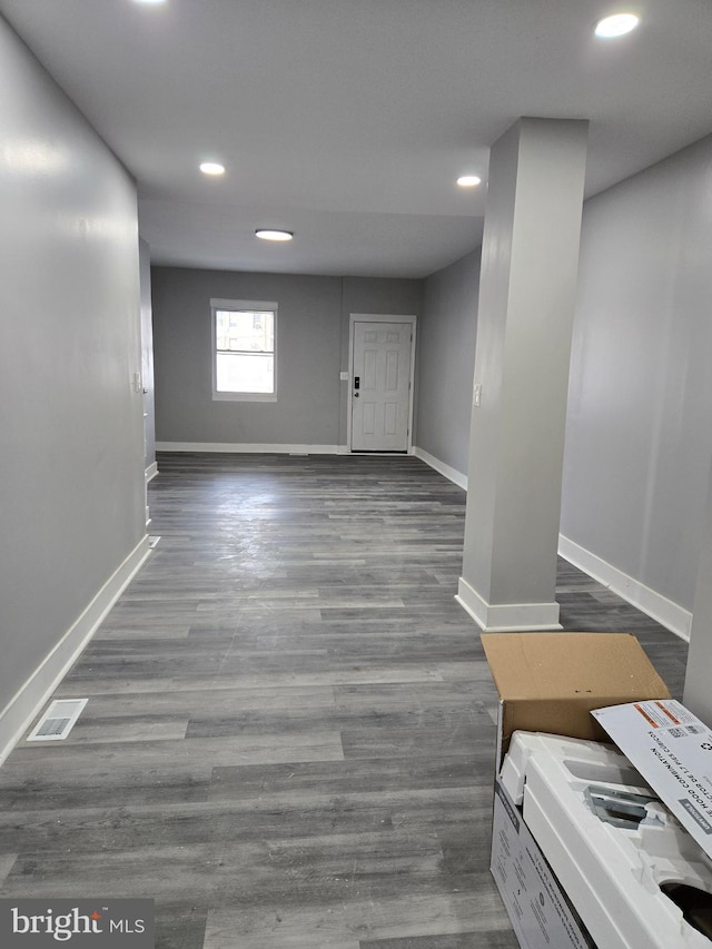 basement featuring recessed lighting, dark wood finished floors, visible vents, and baseboards