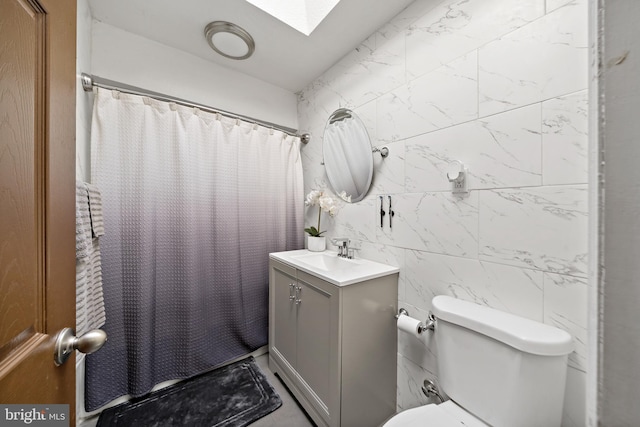 full bathroom featuring a skylight, tile walls, a shower with shower curtain, toilet, and vanity