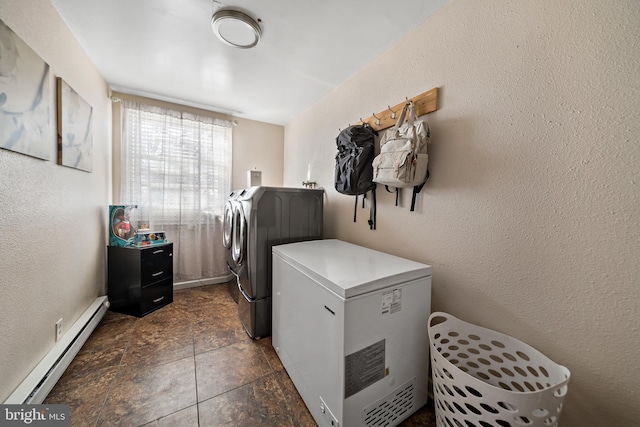 clothes washing area with laundry area, a baseboard radiator, a textured wall, and independent washer and dryer