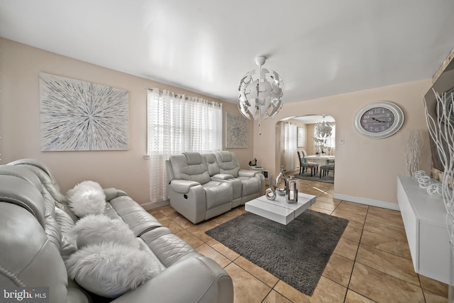 living room with arched walkways, light tile patterned floors, and baseboards