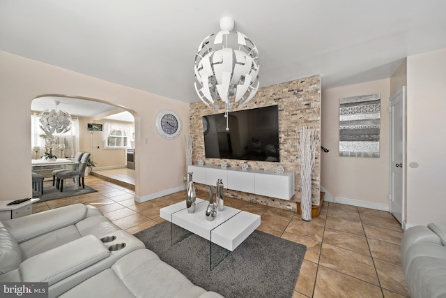 living room with light tile patterned floors, baseboards, and arched walkways