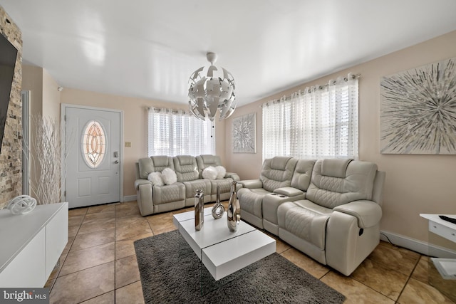 living area featuring a notable chandelier, baseboards, and light tile patterned floors