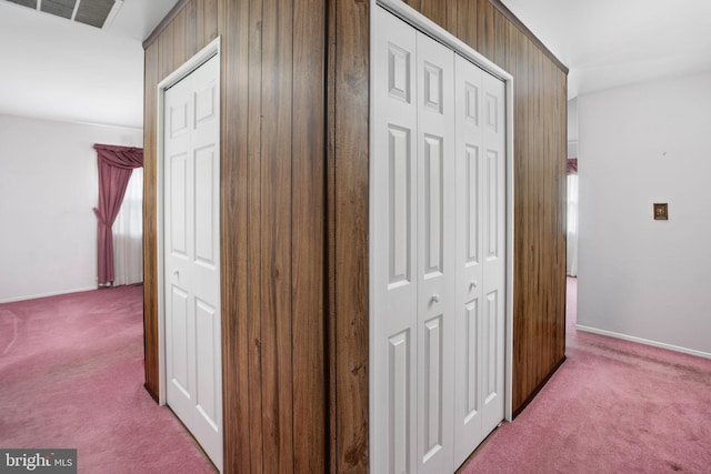 corridor with carpet, visible vents, and baseboards