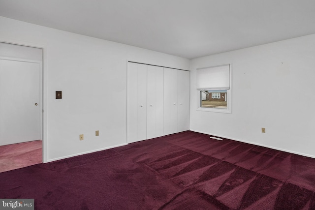 unfurnished bedroom with a closet, carpet flooring, and baseboards