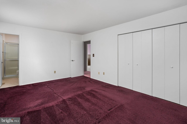 unfurnished bedroom featuring a closet, carpet flooring, and ensuite bathroom