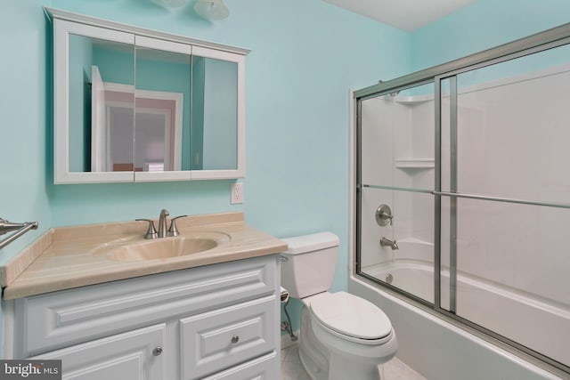 bathroom featuring toilet, combined bath / shower with glass door, and vanity