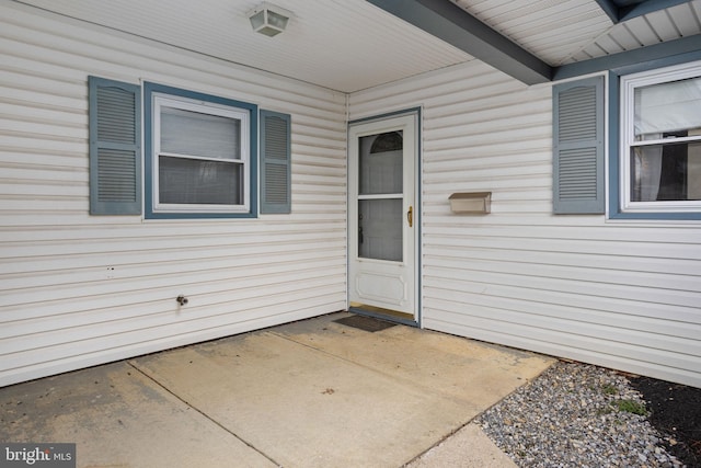 view of exterior entry with a patio