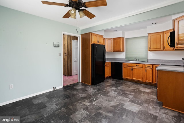 kitchen with stone finish flooring, a sink, baseboards, light countertops, and black appliances