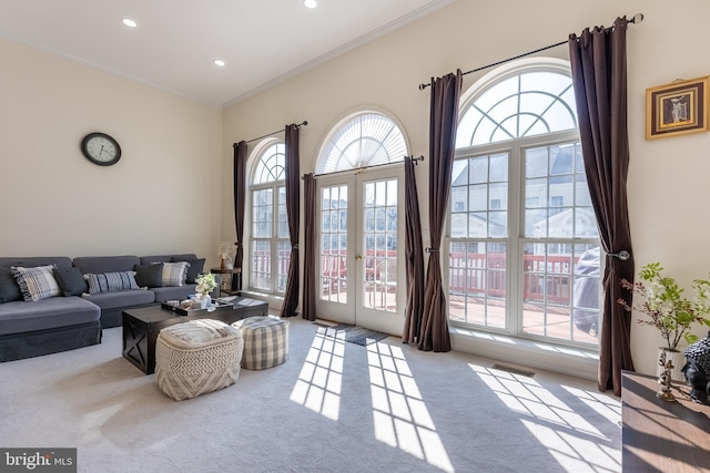 carpeted living room with crown molding, recessed lighting, and french doors