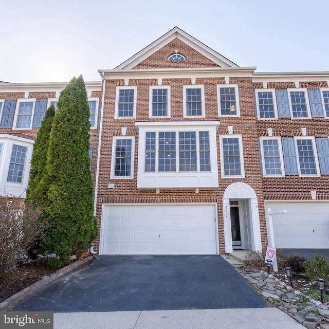 view of front of property with aphalt driveway, a garage, and brick siding