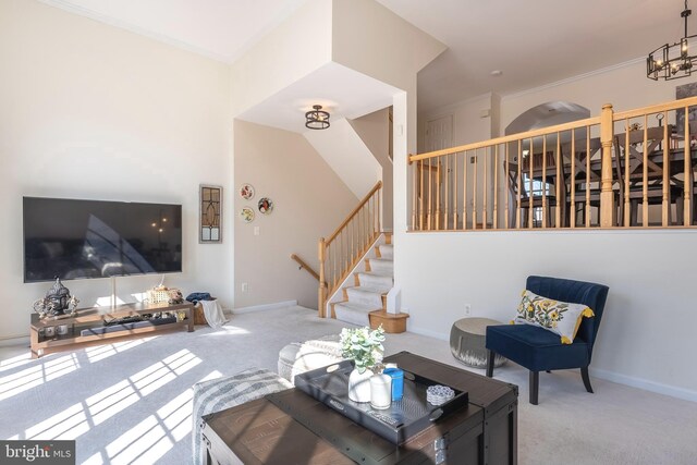 carpeted living area featuring baseboards, a chandelier, and stairs