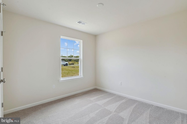 unfurnished room featuring light carpet, visible vents, and baseboards