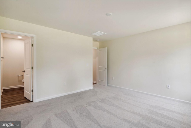 carpeted spare room with visible vents and baseboards