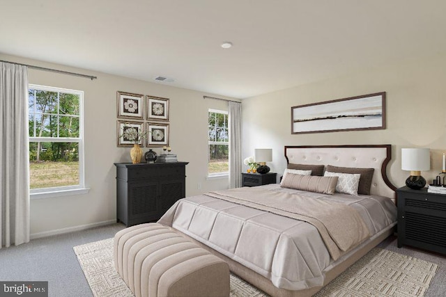 bedroom with light carpet, visible vents, and baseboards