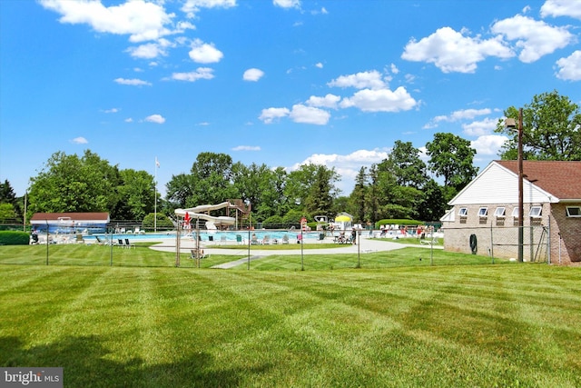 view of yard with fence and a community pool