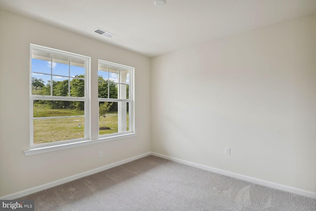 carpeted empty room featuring visible vents and baseboards