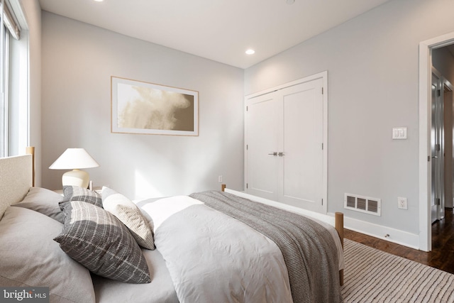 bedroom with baseboards, wood finished floors, visible vents, and recessed lighting