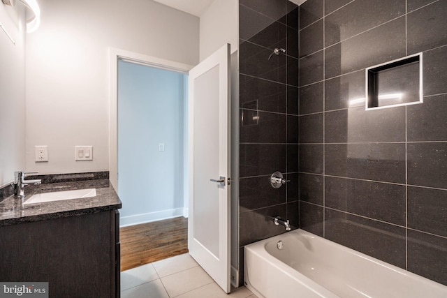 bathroom with tile patterned flooring, vanity, baseboards, and shower / bathtub combination