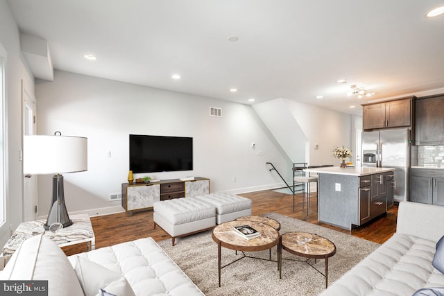 living area with dark wood-style floors, recessed lighting, visible vents, and baseboards