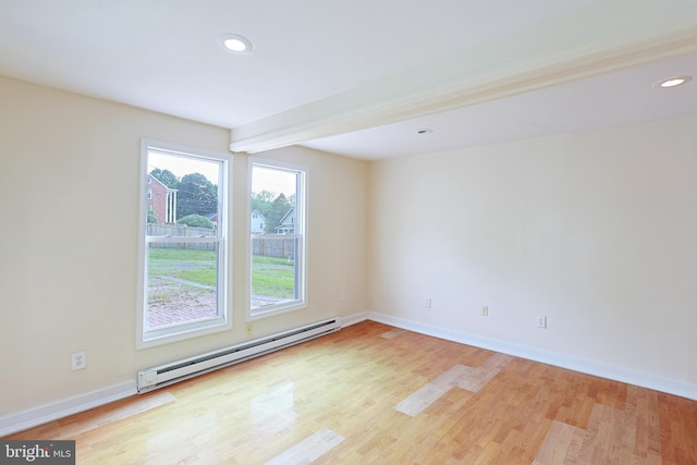 unfurnished room with light wood-style floors, baseboards, and a baseboard heating unit