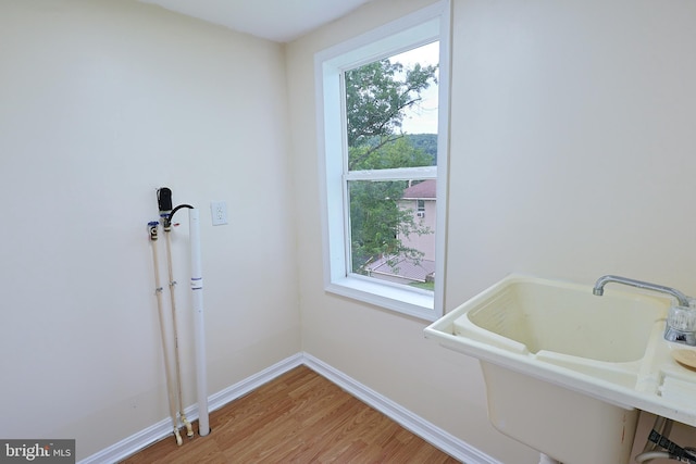 bathroom with a sink, baseboards, and wood finished floors