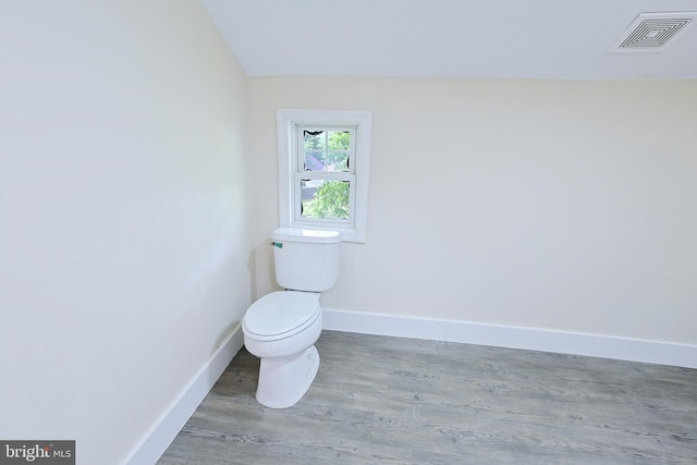 bathroom with toilet, wood finished floors, visible vents, and baseboards