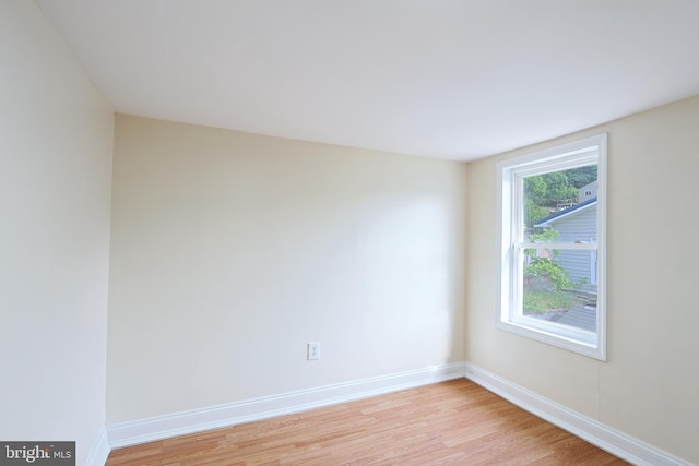 empty room with light wood finished floors and baseboards