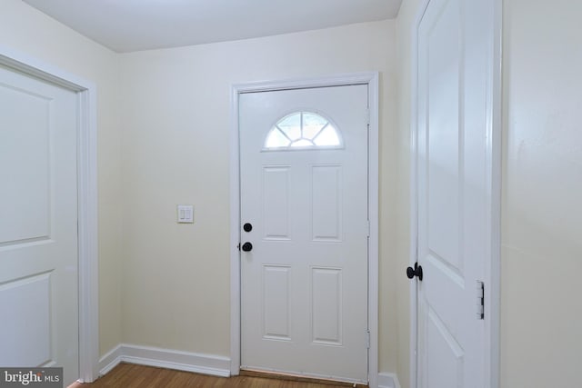 doorway to outside with wood finished floors and baseboards