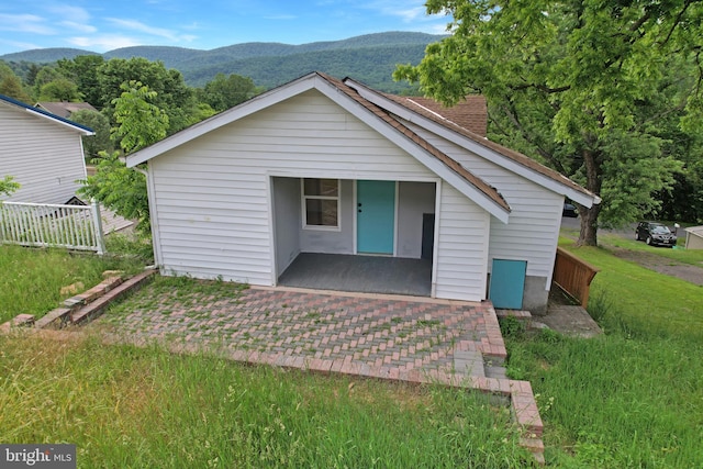 view of front of property with a mountain view and fence