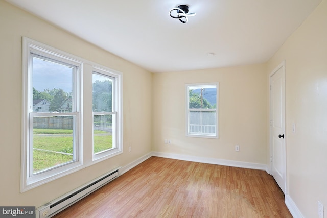 unfurnished room with light wood-type flooring, baseboards, and baseboard heating