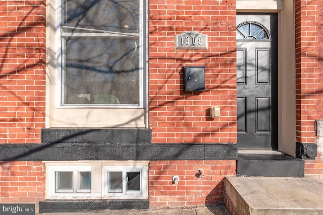 doorway to property with brick siding