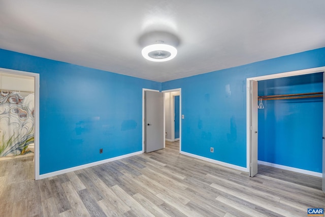 unfurnished bedroom featuring a closet, wood finished floors, and baseboards