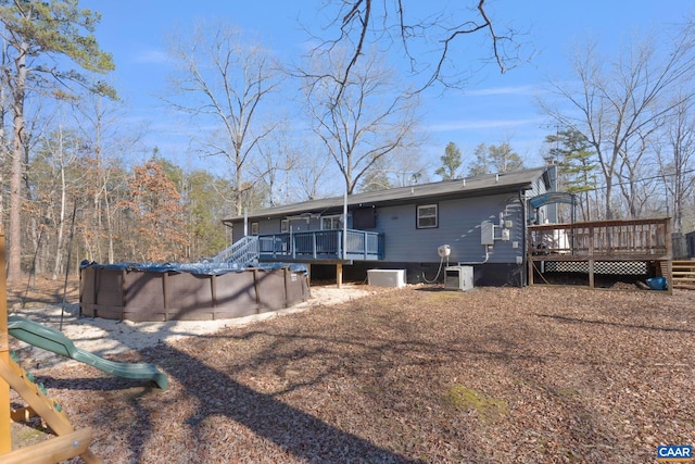 back of house featuring an outdoor pool, central air condition unit, and a deck