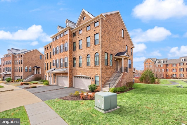 exterior space featuring driveway, a garage, a front lawn, and brick siding