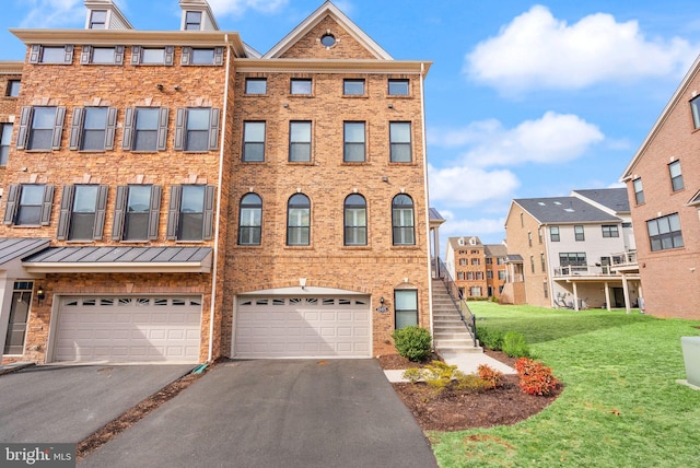 townhome / multi-family property featuring driveway, an attached garage, a front lawn, and brick siding