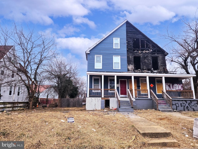 view of front of house with a porch and fence