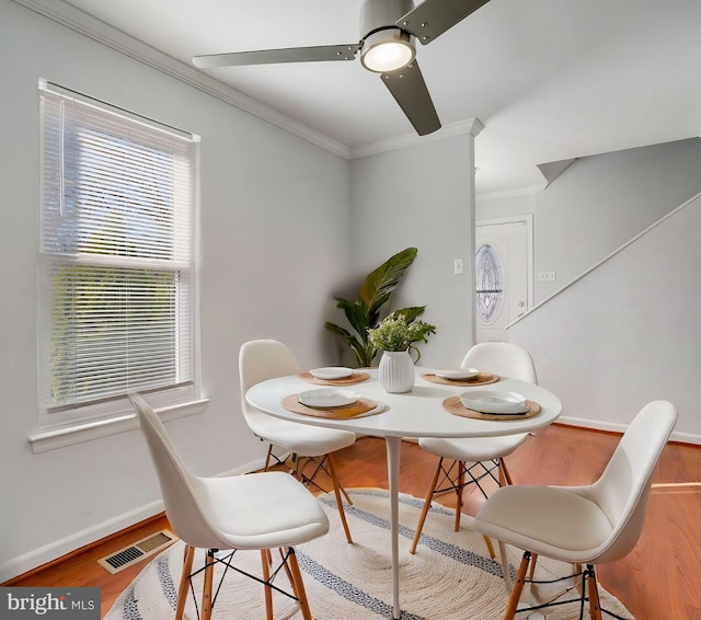 dining area featuring baseboards, crown molding, visible vents, and wood finished floors