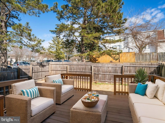 wooden deck featuring outdoor lounge area and a fenced backyard