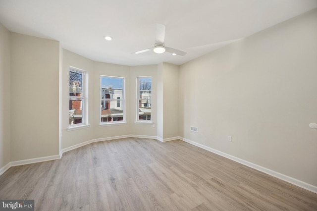 empty room featuring wood finished floors, a ceiling fan, and baseboards