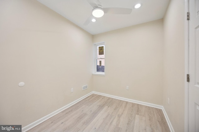 empty room featuring baseboards, a ceiling fan, visible vents, and light wood-style floors