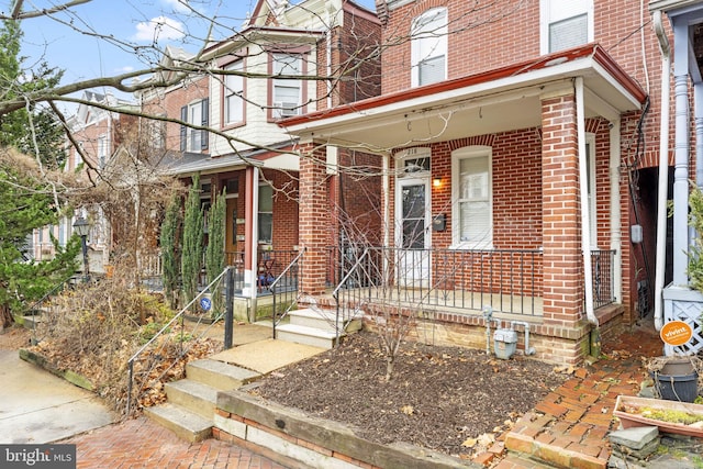 view of front of property featuring covered porch and brick siding