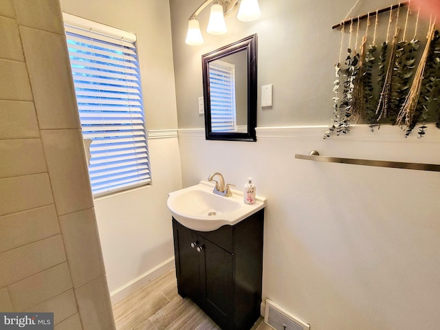 bathroom with wood finished floors, vanity, visible vents, and baseboards