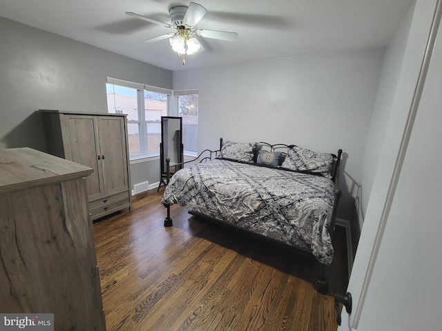 bedroom featuring visible vents, baseboards, dark wood finished floors, and a ceiling fan