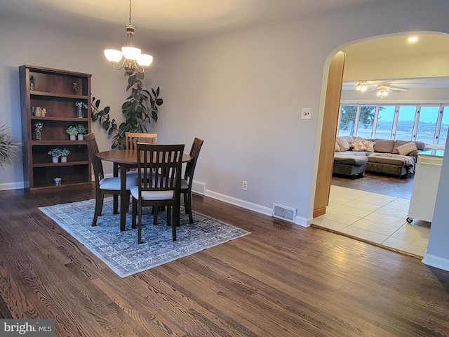 dining area with visible vents, arched walkways, and wood finished floors