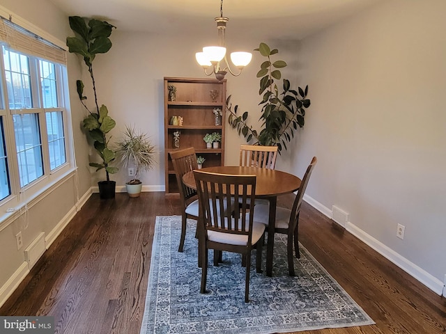 dining space with a chandelier, baseboards, and wood finished floors