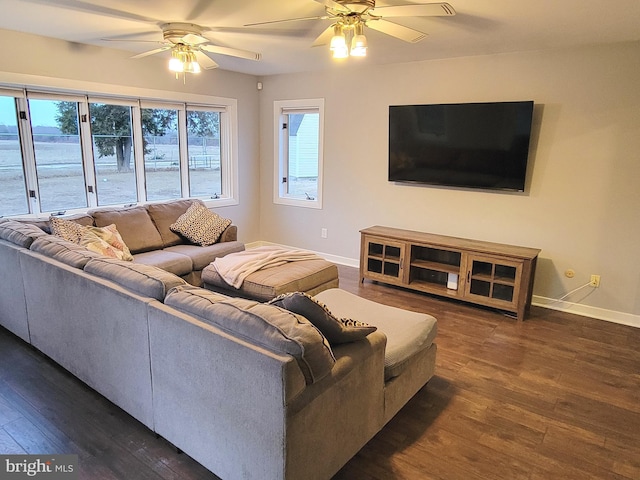 living room featuring a ceiling fan, baseboards, and dark wood-type flooring