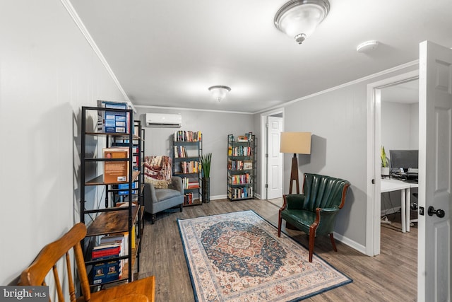 sitting room with a wall mounted air conditioner, wood finished floors, and crown molding